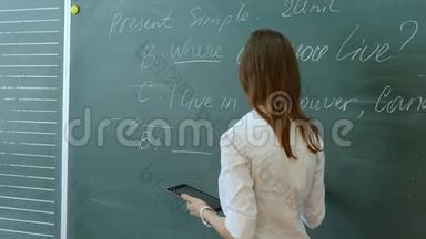 年轻的女教师在学校的<strong>课堂</strong>上和<strong>课堂</strong>上谈论英语课。